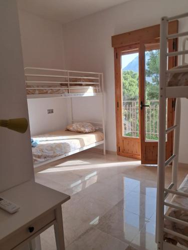 a room with two bunk beds and a sliding glass door at El balcón de Cuadros in Jaén