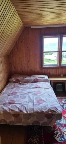 a bed in a wooden room with a window at Macanovic Country House in Glibaći