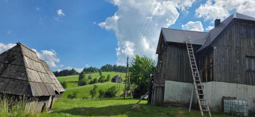 an old barn with a ladder next to a house at Macanovic Country House in Glibaći