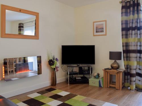 a living room with a flat screen tv on the wall at 18 Elm Court in Keswick