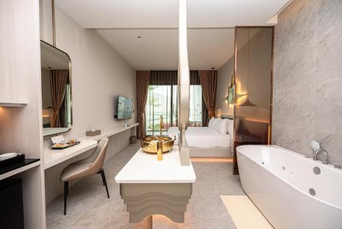 a bathroom with a bath tub and a bedroom at The Rachata at Ayothaya in Ban Khlong Takhian