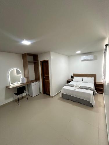 a bedroom with a bed and a desk in it at Hotel Pacaraima in Mecalineta