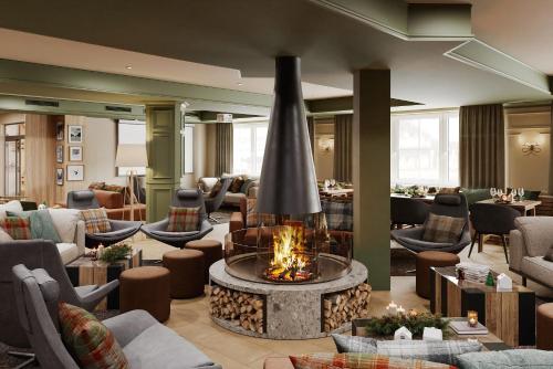 a hotel lobby with a fireplace in the middle at VALAMAR Obertauern in Obertauern
