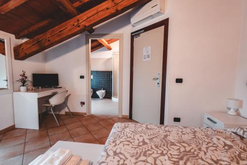 a bedroom with a bed and a desk at Black Paradise Room in Soliera