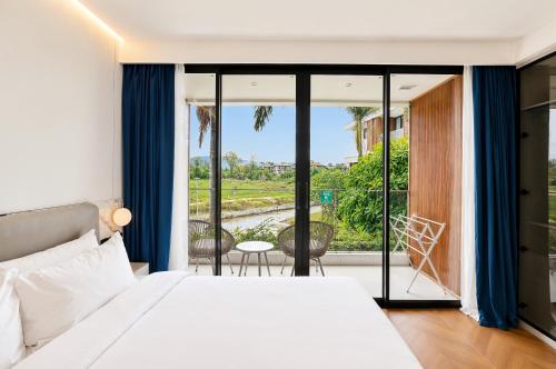 a bedroom with a bed and a balcony with a view at Beachfront Luxury Apartment Bangtao Phuket in Bang Tao Beach