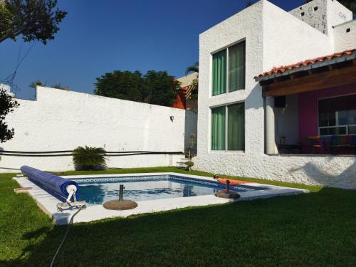 a swimming pool in the yard of a house at Casa Tikul in Temixco