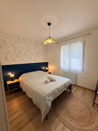 a bedroom with a bed and a window at La Parenthèse de Quantilly in Quantilly