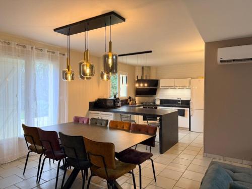 a kitchen and dining room with a table and chairs at La Parenthèse de Quantilly in Quantilly