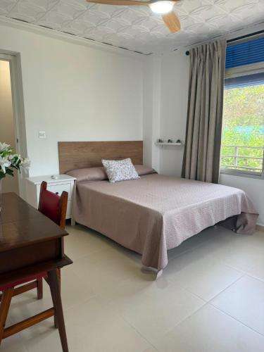 a bedroom with a bed and a table and a window at La Barraca in Gandía