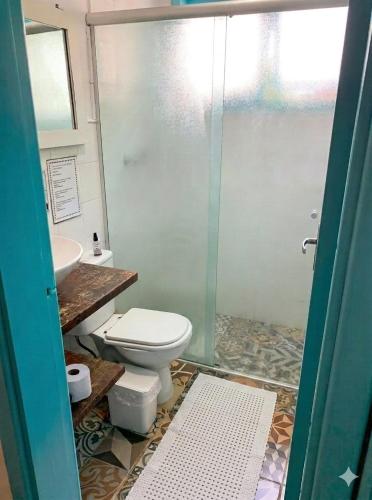 a bathroom with a toilet and a glass shower at Zeisa House in Maresias