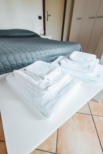a pile of white towels sitting on a white table at Black Paradise Room in Soliera