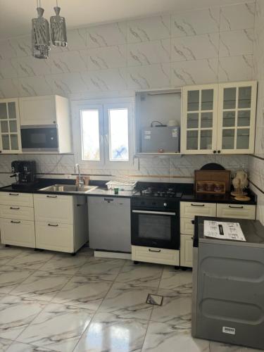 a kitchen with white cabinets and a stove top oven at Venice Private Retreat Tripoli, Libya in Tripoli