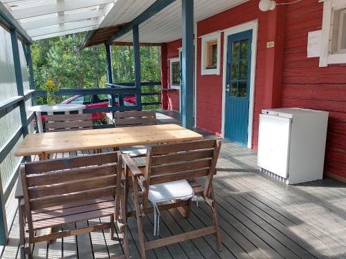 a wooden table and chairs on the porch of a house at Takalahti Lodge in Puumala