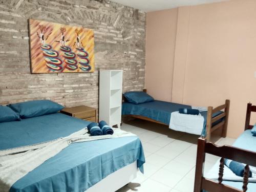 a bedroom with two beds and a painting on the wall at Origem Bahía in Salvador