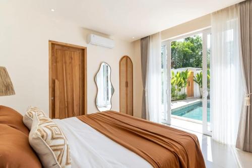 a bedroom with a bed and a swimming pool at Villa Candi - Stylish Tropical Pool Villa in Ungasan