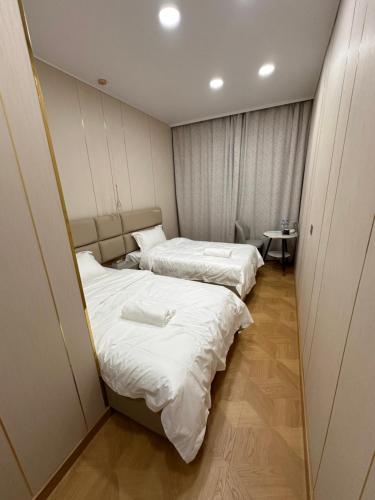 two beds in a small room with white sheets at Zarya in Ölgiy