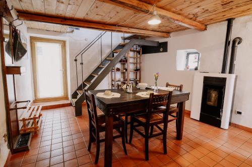 a dining room with a table and chairs and a staircase at Casa Acquarossa in Rubiana