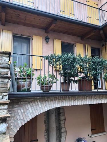 a balcony with potted plants on a building at Mirella house Desenzano del Garda -Centro storico, 30 mt dal lago in Desenzano del Garda