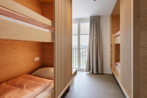 a bedroom with two bunk beds and a window at Geneva Youth Hostel in Geneva