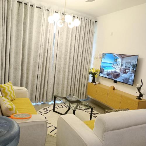 a living room with a couch and a tv at Zurilyn Crib in Malindi