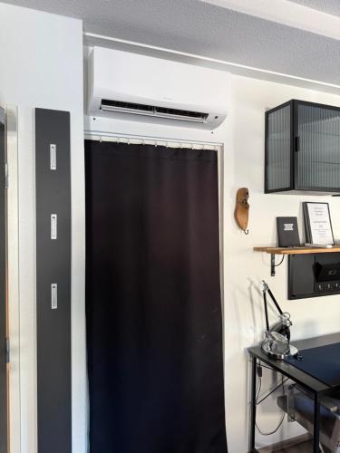 a black shower curtain in a room with a desk at Loviisan Helmi 102 in Loviisa
