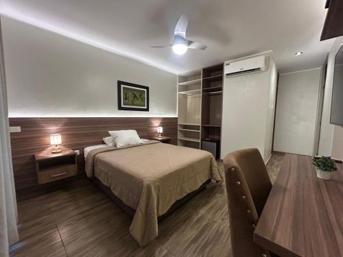a bedroom with a bed and a table and a chair at Hotel La Colina in Ica