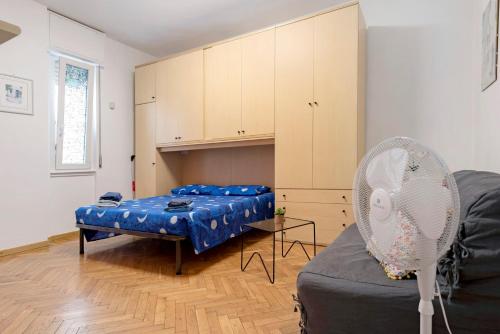 a room with a bed and a cabinet and a fan at La Casetta di G&G in Varese