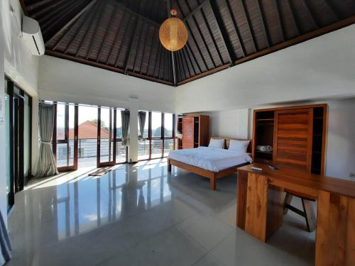 a bedroom with a bed and a desk and some windows at Serenity Nirvana Palace Jimbaran - Near Uluwatu in Jimbaran