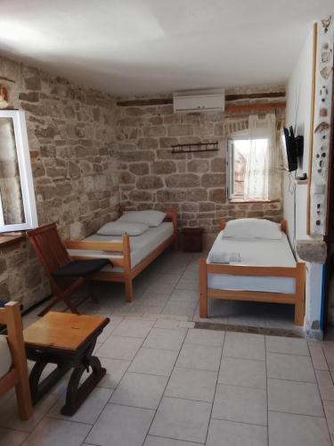 a room with two beds in a brick wall at Slavko in Hvar