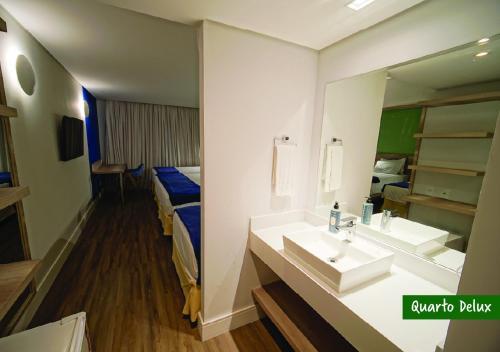 a bathroom with a sink and a mirror at Itapura Eco Resort in Atibaia