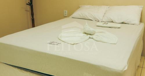 a white bed with a bow tie on it at Varanda Atlantica Casa Camocim enfrente a praia in Camocim
