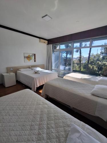 a hotel room with two beds and a window at Estrela Palace Hotel in Estrêla