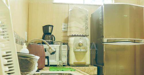 a kitchen counter with a mixer and a refrigerator at Varanda Atlantica Casa Camocim enfrente a praia in Camocim