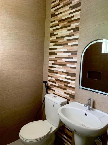 a bathroom with a toilet and a sink at Ricres Hometel R3 in Babak