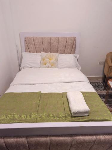 a bedroom with a large bed with two towels on it at Gweth Haven Homes in Nakuru