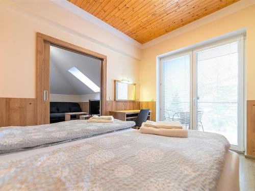 two beds in a room with a large window at Apartmány Superior Vila Věra in Rožnov pod Radhoštěm