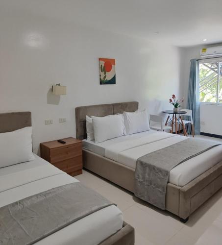 a bedroom with two beds and a window at Ricres Hometel R3 in Babak