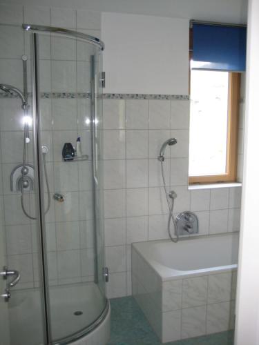 a bathroom with a shower and a tub and a toilet at Ferienhaus Stemer Montafon in Schruns