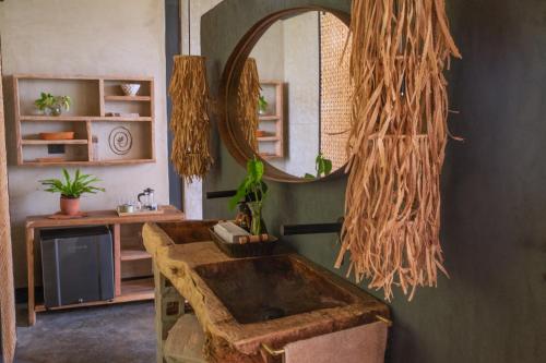 een badkamer met een houten wastafel en een spiegel bij Macana Eco Hotel in Montenegro