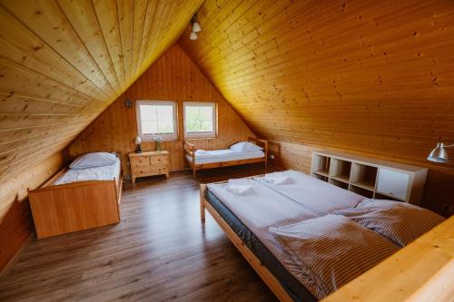 a attic room with two beds in a wooden house at U Marcjana in Kamienica Królewska