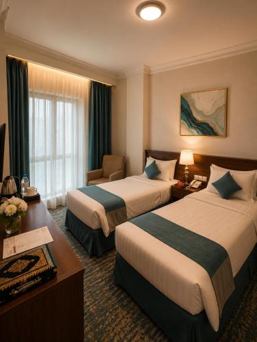 a hotel room with two beds and a desk at Zaha Al Madina Hotel in Medina