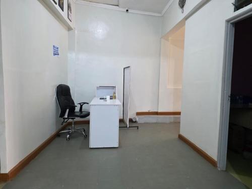 an empty room with a desk and a chair at EMJAYS guest house in Eldoret