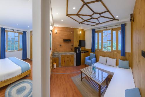 a bedroom with a bed and a living room at Manu Villa Manali - A Beautiful Cottage towards Snow Capped Mountain in Manāli