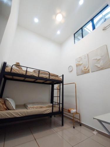 a bedroom with two bunk beds and a window at Golden Paradise Fully Aircond in Kuantan