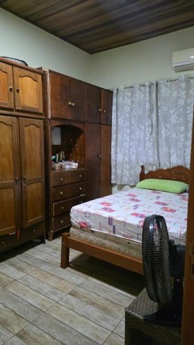 a bedroom with a bed and wooden cabinets at Casa em Sítio, 7km da Cidade in Poconé