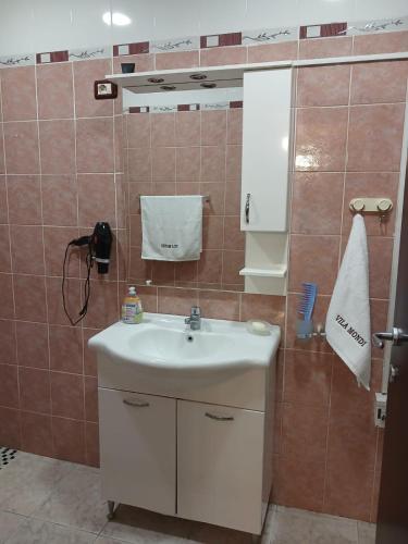 a bathroom with a white sink and a mirror at Villa Mondi in Durrës