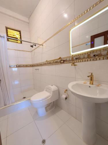a white bathroom with a sink and a toilet at Hostel Sillustani Inn Puno - Con Cochera in Puno