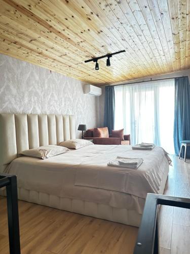a bedroom with a large bed with a wooden ceiling at Davit batoni Apartment in Mtskheta in Mtskheta