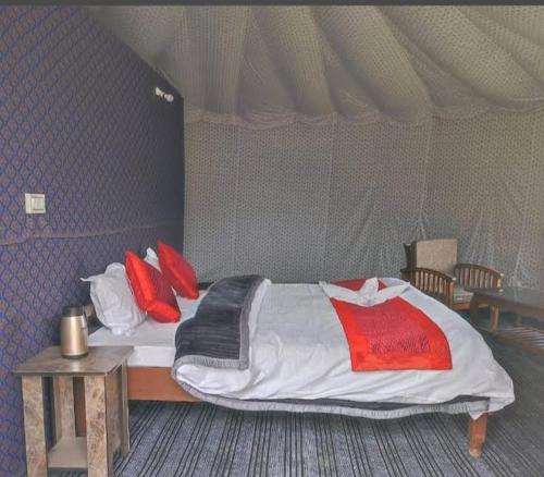 ein Bett in einem Zelt mit roten Kissen darauf in der Unterkunft D cottage in Man