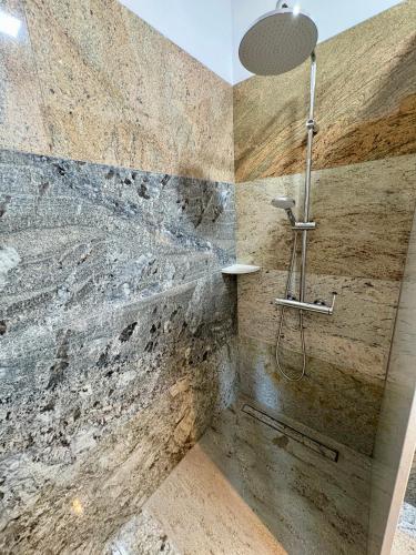 a bathroom with a shower with a stone wall at Perła Chmielna in Chmielno
